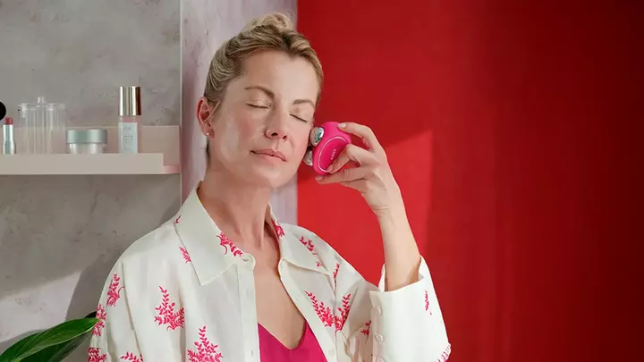 A woman using the microcurrent face lift device 
